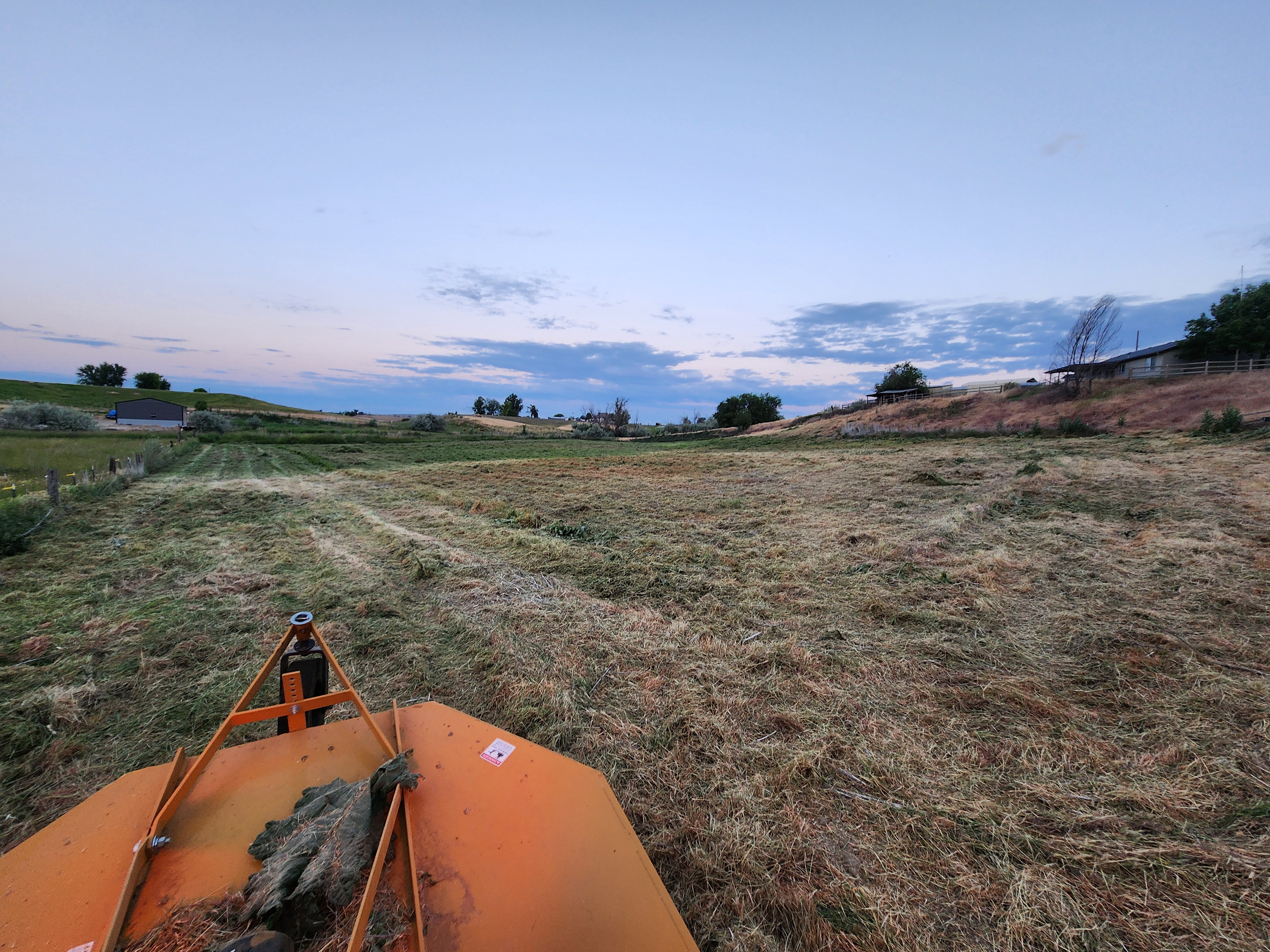 Scott standing next to his Mahindra tractor in a field